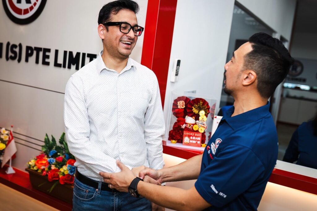 A Ritchmen team member shaking hands with a guest in the company reception area.